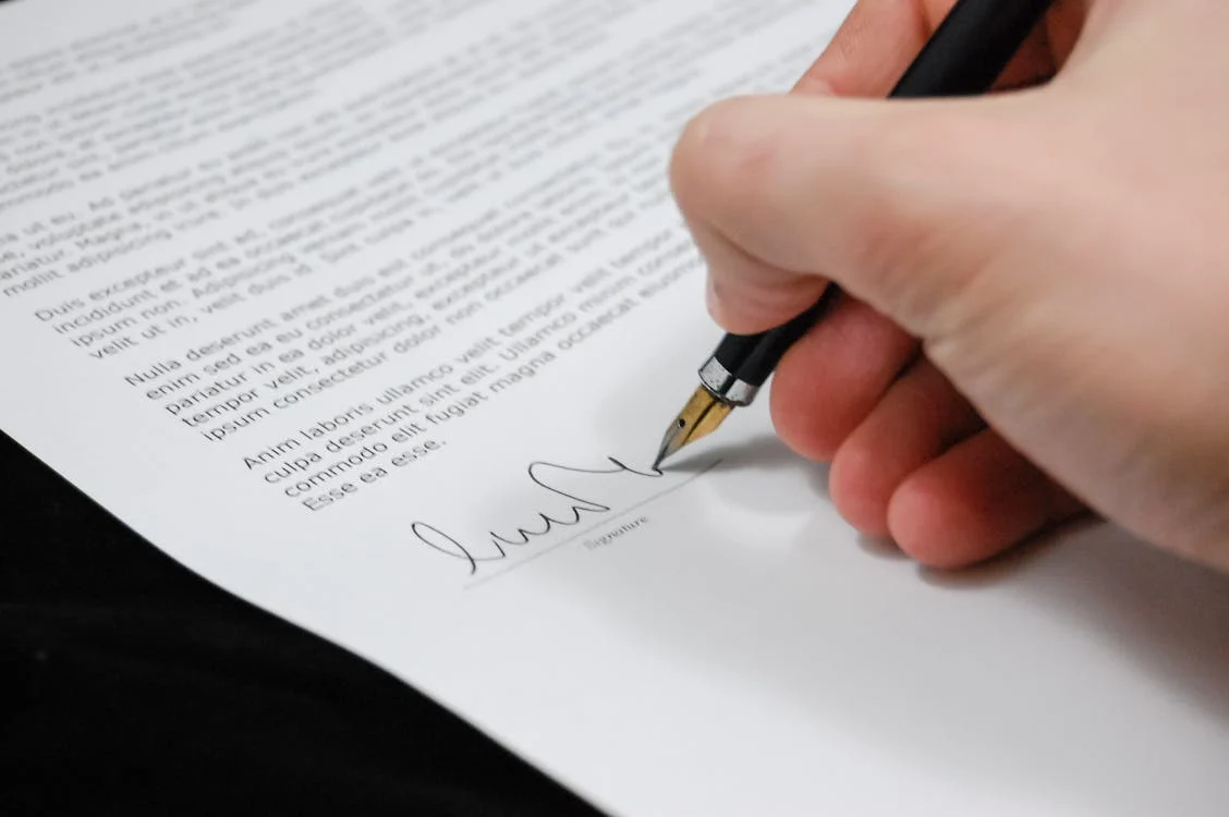 picture of a hand signing a document