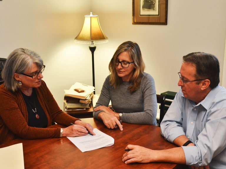 Carolyn helping clients sign documents